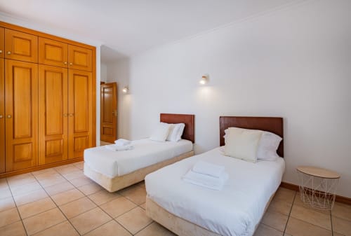 Quarto duplo na Villa Rosal by SignatureStays em Albufeira com roupeiros em madeira e porta de casa de banho
