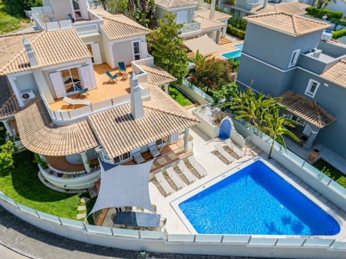 Vista aérea da Villa Rosal em Albufeira com apartamentos à beira da piscina, telhados de terracota e piscina azul