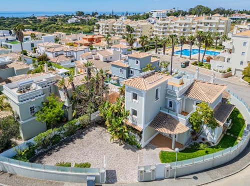 Vista aérea do Apartamentos Villa Rosal em Albufeira com piscina, palmeiras e arquitetura mediterrânea