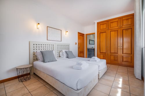 Quarto twin da Villa Rosal, apartamento SignatureStays em Albufeira com roupeiros em madeira e pisos em terracota
