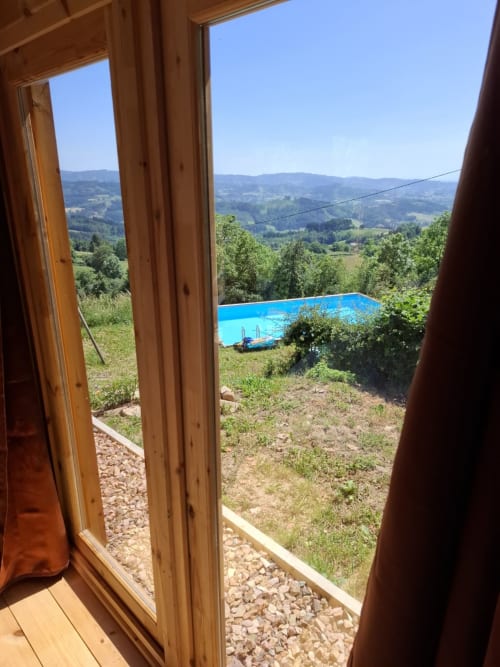 View from Cèdre Bleu room at La Maison de Dun, showing pool and rolling mountains in Saint Racho