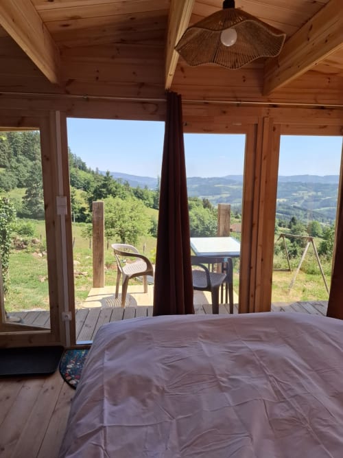 Bedroom in Cèdre Bleu room at La Maison de Dun B&B with panoramic mountain views from large windows