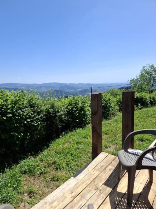 Wooden deck overlooking rolling vineyards and green hills at La Maison de Dun, Saint Racho