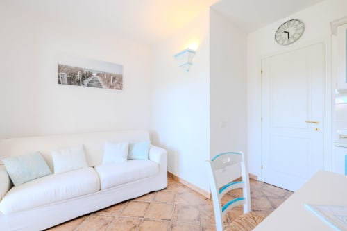 Luminoso salotto con divano bianco, pavimenti in terracotta e comfort moderni nella villa Poggio dei Fiori, Olbia