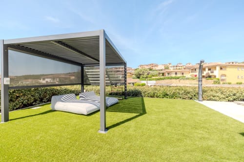 Terrazza di villa moderna con mobili lounge, pergolato e prato curato a Olbia, Italia