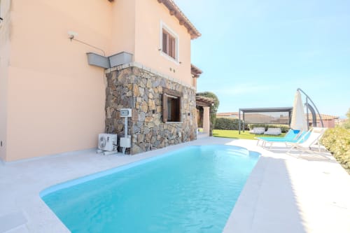 Villa Poggio dei Fiori a Olbia con piscina turchese, ingresso in pietra, lettini e giardino curato