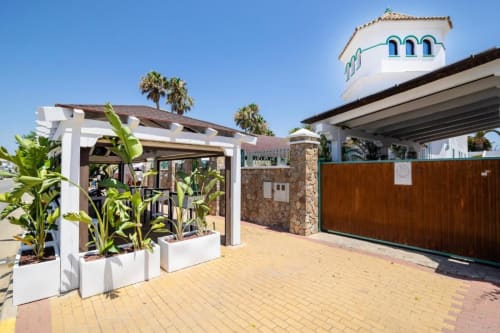 Patio del Hotel Boutique Zahara con pérgola blanca, plantas tropicales y arquitectura mediterránea en Zahara de los Atunes
