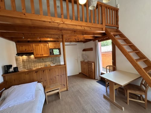 Studio Confort Mezzanine à Brides-les-Bains avec mobilier en bois, kitchenette et accès à la vue montagne