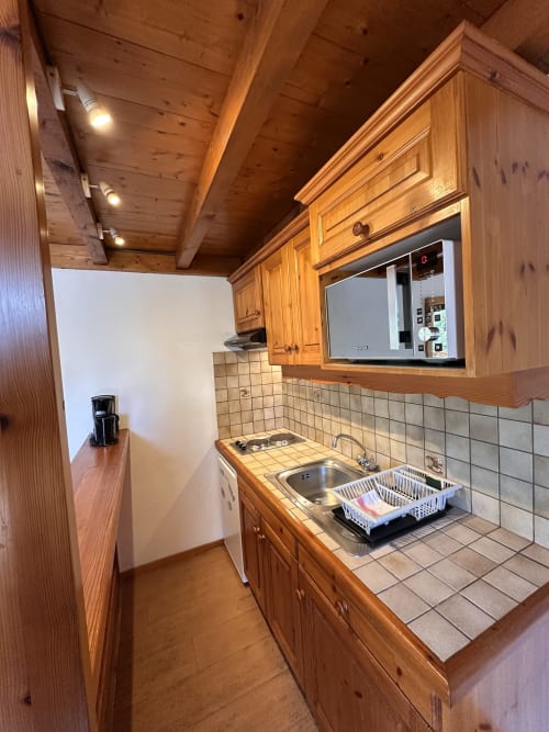 Petite kitchenette du Studio Confort Mezzanine à l'Hôtel Studios La Rochetaillée, Brides-les-Bains, avec meubles en bois