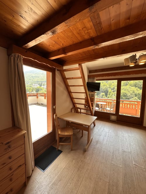 Studio Confort Mezzanine à l'Hôtel Studios La Rochetaillée : poutres apparentes, vue montagne depuis balcon, chambre en mezzanine