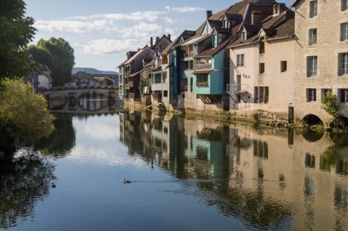 Bâtiments historiques en pierre reflétés dans la rivière du Doubs, Vallée du Lison, France - Gîtes