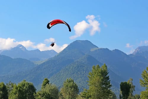 Parapentiste survolant les montagnes alpines forestières près de la vallée du Doubs, Eternoz, France
