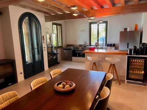 Moderner Speisebereich der Villa Prince Garda Salò mit Holztisch, zeitgenössischen Stühlen, offener Küche und Seeblick