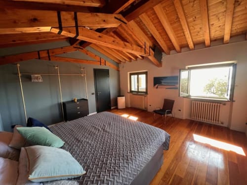 Geräumiges Schlafzimmer mit Holzbalken, Queensize-Bett und Seeblick im Prince Garda in Salò