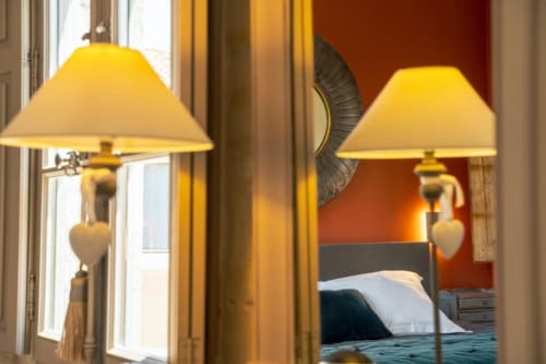 Deux élégantes lampes de table aux abat-jour jaunes dans la suite Les Jardins d'Alhambra de l'hôtel d'Avignon, vue sur le jardin