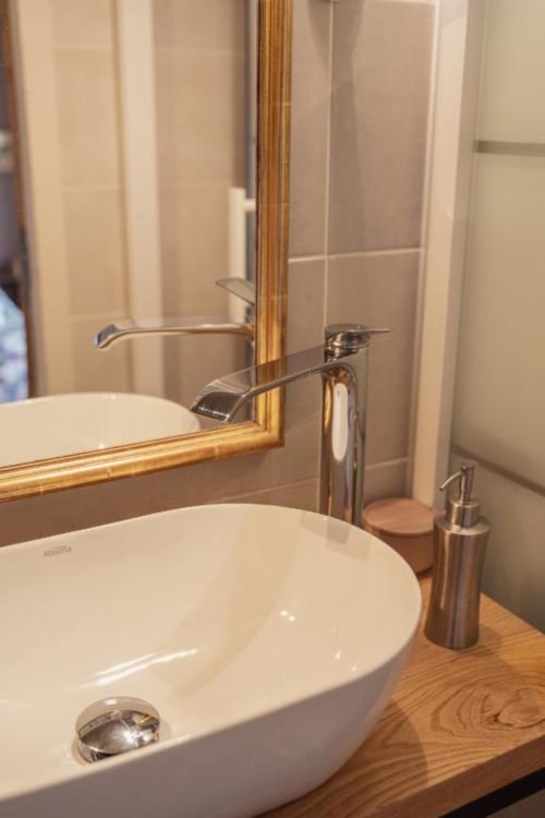 Lavabo de salle de bain moderne avec robinetterie chromée et miroir encadré doré aux Jardins de Baracane, Avignon