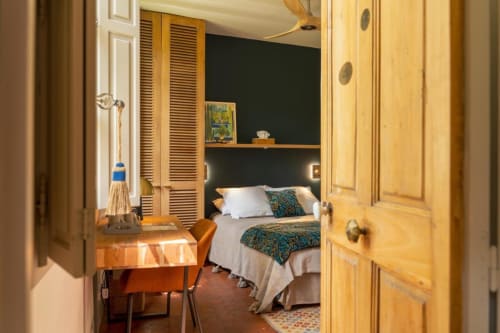 Chambre à Les Jardins de Baracane Avignon B&B avec portes en bois, bureau et salle d'eau