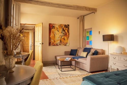 Suite chambre accueillante aux Jardins de Baracane Avignon : canapé beige, œuvres d'art et équipements modernes