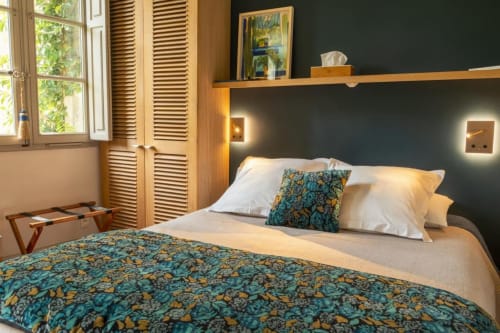 Chambre moderne aux Jardins de Baracane Avignon avec literie turquoise patterned, mobilier bois et vue jardin