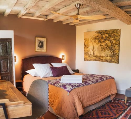 Chambre chaleureuse et rustique aux Jardins de Baracane avec poutres en bois, murs en terre cuite, décor avec vue jardin et confort