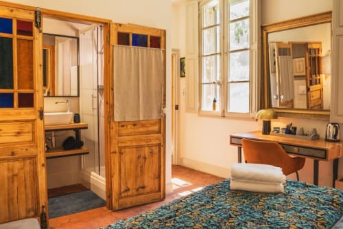 Chambre spacieuse avec meubles en bois, salle de bain privée et bureau aux Jardins de Baracane à Avignon