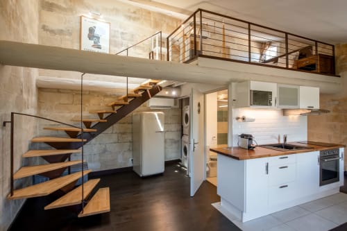Loft moderne à Villeneuve-lès-Avignon avec cuisine ouverte, escalier bois et mezzanine.