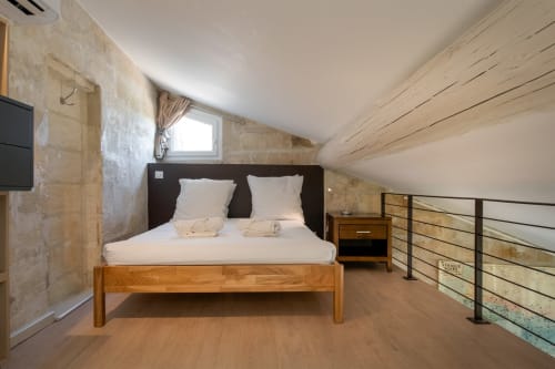 Chambre mansardée de l'appartement ORIGAN St Eloi à Villeneuve-lès-Avignon avec lit bois, linge blanc et poutres apparentes