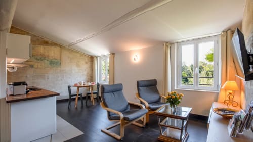 Séjour moderne avec cuisine, salle à manger, deux fauteuils bleus et vue sur les montagnes à Villeneuve-lès-Avignon