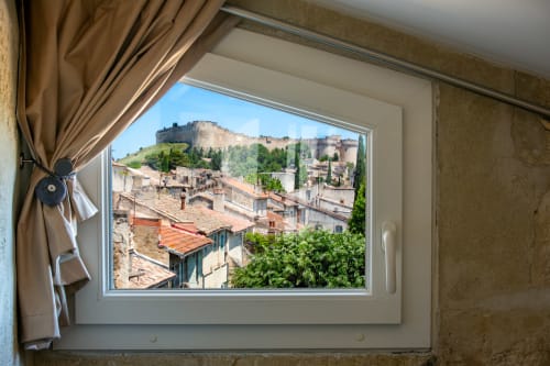 Vue depuis la fenêtre de l'appartement St Eloi sur Villeneuve-lès-Avignon avec son château historique et toits en terre cuite
