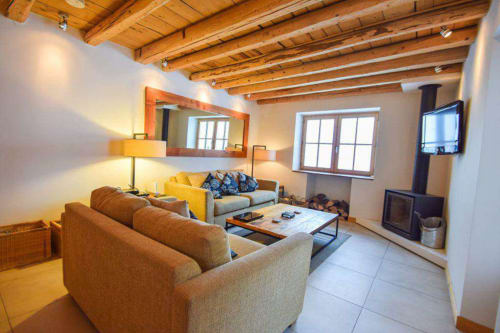 Séjour douillet du Chalet Savoyard à La Plagne avec poutres apparentes, sièges confortables et équipements modernes