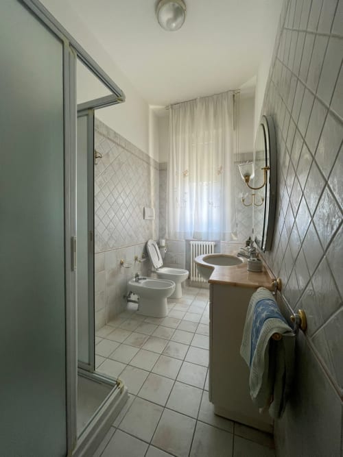 Moderno bagno nell'appartamento di LHE Street Forlì, Italia, con toilet, bidet, lavabo, box doccia e pareti piastrellate