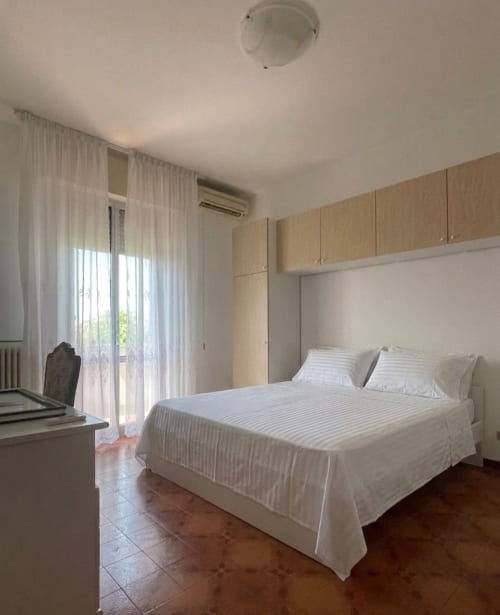 Camera moderna nell'appartamento di Forlì con letto matrimoniale, armadi in legno, accesso alla terrazza e vista sulla città