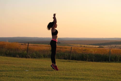 Woman jumping in field at sunset near Monte da Morena, Serpa Portugal rural accommodation