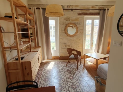 Chambre d'hôte lumineuse et aérée au Mas des Ecoliers en Provence avec mobilier en bois, lampe suspendue tressée et décor traditionnel