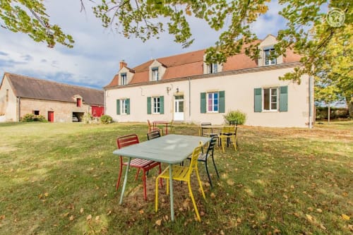 Espace de restauration en plein air au gîte Au 3 Cyprès de Précy à Neuvy Grandchamp, avec chaises et table colorées
