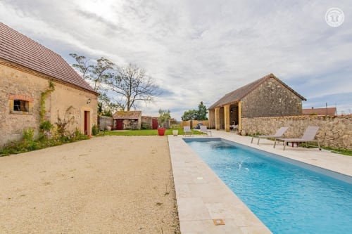 La piscine et les bâtiments en pierre du Au 3 Cyprès de Précy à Neuvy Grandchamp, France