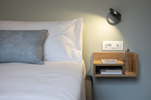 Camera moderna a Camere d'Aria B&B a Locana con letto, cuscino grigio, comodino in legno e lampada da parete