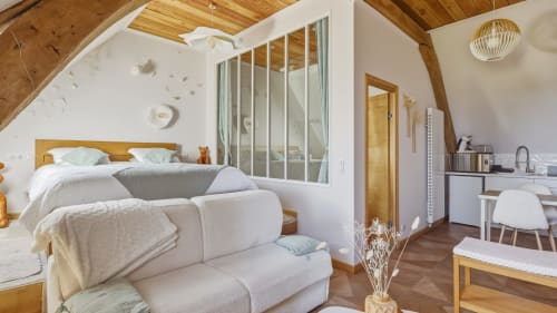 Chambre La Mezzanine de l'Etoile avec canapé blanc, lit en bois et espace de travail à L'Etoile De Forges BnB à Longmesnil, France