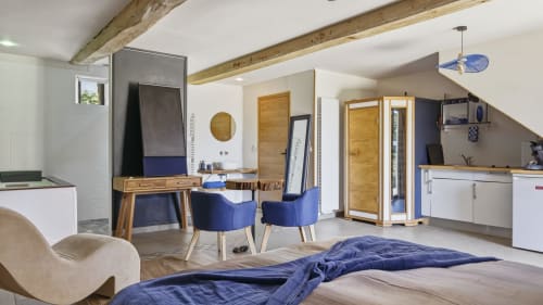 La suite de l'Etoile cottage bedroom with blue accent chairs, wooden beams, and modern amenities at L'etoile De Forges,