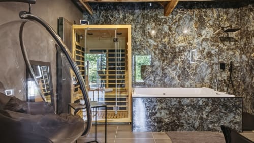 Salle de bain spa luxe au gîte L'etoile De Forges avec sauna, bain à remous et murs effet marbre à Longmesnil