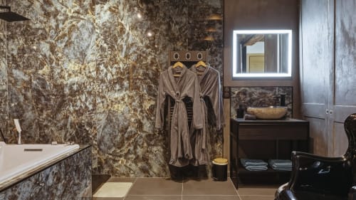 Salle de bain luxueuse du Duplex de l'Étoile à L'Étoile De Forges : murs en marbre, miroir rétroéclairé et spa