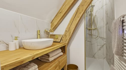 Salle de bain moderne au Studio de l'Etoile à L'Etoile De Forges avec meuble vasque en bois, lavabo blanc, carrelage marbre et verre