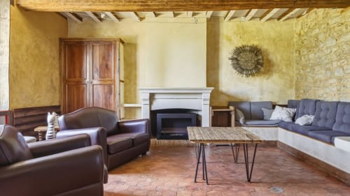 Spacieux salon du cottage à L'etoile De Forges avec sièges en cuir, cheminée et carrelage en terre cuite rustique