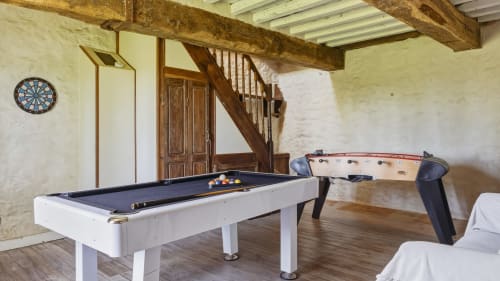 Salle de jeux du gîte L'Étoile De Forges avec billard, baby-foot, fléchettes, poutres en bois et escalier