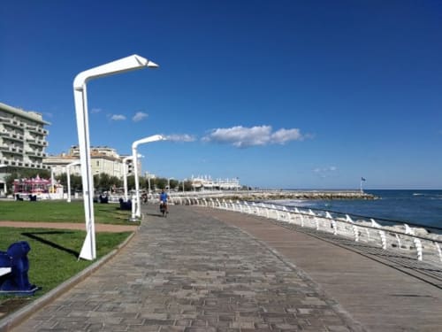 Lungomare di Pesaro con lampioni bianchi, area verde e vista sul Mare Adriatico vicino all'hotel Riviera Apartments