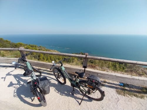 Due biciclette parcheggiate alla ringhiera in legno con vista sul turchese Mare Adriatico, Riviera Apartments, Pesaro