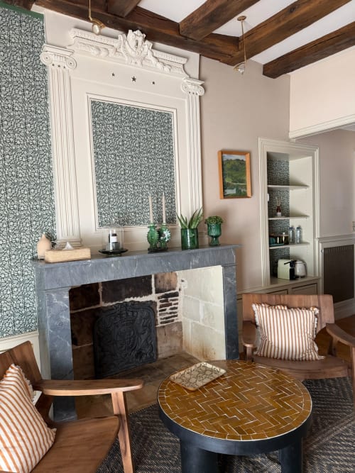 Élégant salon de Maison Romy avec cheminée, panneaux muraux décoratifs, poutres en bois et mobilier mid-century