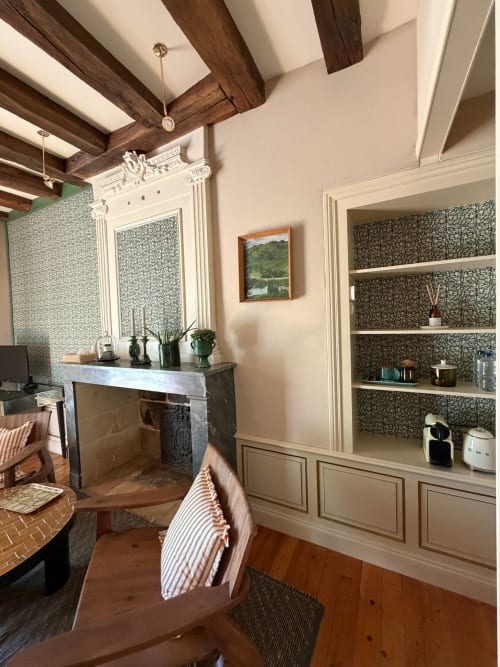 Chambre élégante à la Maison Romy avec poutres apparentes, cheminée et étagères intégrées dans ce gîte français
