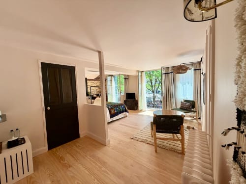 Chambre Balthazar à la Maison Romy : parquets, mobilier contemporain, portes-fenêtres et vue sur la ville