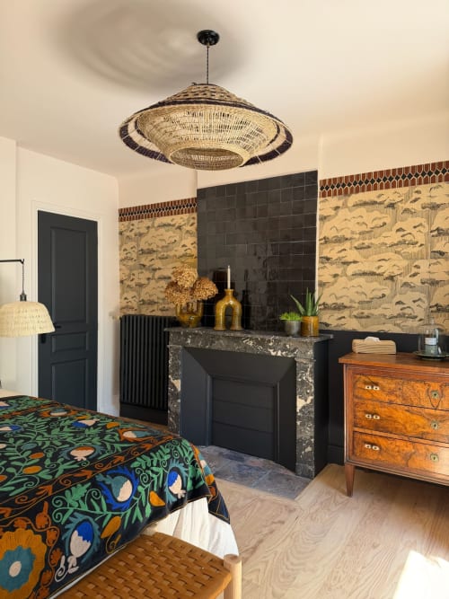 Chambre Balthazar à la Maison Romy avec foyer, suspension tressée et literie aux motifs colorés